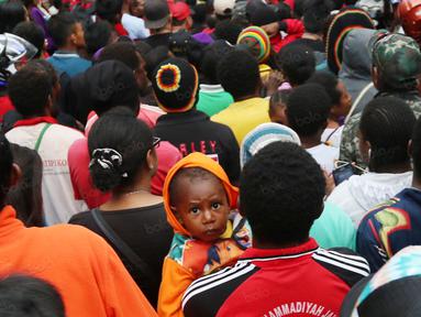 Suporter cilik ikut dalam antrean saat memasuki  areal stadion pada pembukaan Torabika Soccer Championship 2016 di Stadion Mandala, Jayapura, Papua, Jumat (29/4/2016). (Bola.com/Nicklas Hanoatubun)