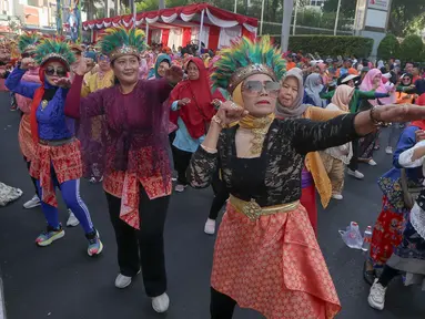 Para perempuan dari segala umur menggelar Flashmob Poco-poco Berkebaya bersama kelompok perempuan lainnya di Bundaran HI, Jakarta, Minggu (14/7/2024). (Liputan6.com/Herman Zakharia)