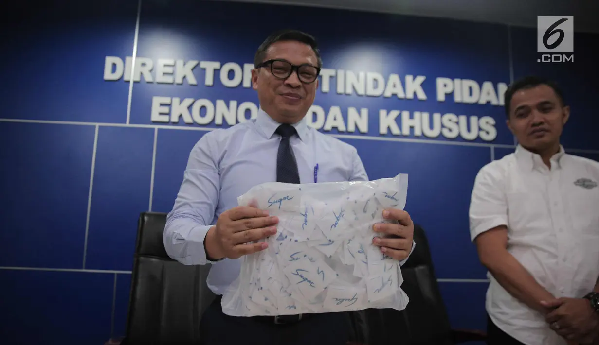 Dir Tipideksus Bareskrim Brigjen Agung Setya (kiri) menunjukkan kemasan gula rafinasi di Gedung Bareskrim, Jakarta, Rabu (1/11). Menurut pihak kepolisian, gula rafinasi tidak layak langsung dikonsumsi dan harus diolah lagi. (Liputan6.com/Faizal Fanani)