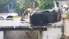 Petugas berusaha mengevakuasi mobil yang terguling di kawasan Pasar Minggu, Jakarta Selatan, Sabtu (8/6/2019) pagi. Mobil yang nyaris tercebur sungai itu dikendarai seorang pemuda yang nekat melakukan aksi kebut-kebutan saat jalanan ibu kota lengang. (Liputan6.com/Herman Zakharia)