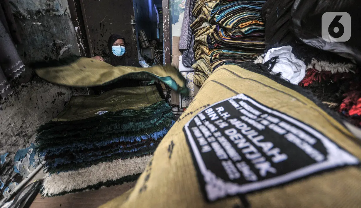 Fitri (40) menyelesaikan jasa sablon sajadah di Amang Sablon, Kebon Melati, Jakarta Pusat, Kamis (7/4/2022). Amang Sablon kini mampu menyelesaikan produksi sablon sajadah sebanyak 17-20 kodi per hari. (merdeka.com/Iqbal S. Nugroho)