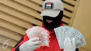Penyidik KPK memperlihatkan barang bukti USD 11 ribu dan Rp60 juta saat konferensi pers, Jakarta, Rabu (2/12/2015). Uang tersebut diamankan oleh penyidik KPK bersama 8 orang diantaranya 2 anggota DPRD Banten di kawasan Serpong. (Liputan6.com/Helmi Afandi)