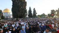 Umat Muslim melaksanakan sholat Idul Fitri di luar masjid Kubah Batu di kompleks masjid Al-Aqsa, Yerusalem Tua (13/5/2021).  Rentetan tembakan roket dari Gaza dan serangan udara Israel yang mematikan sebagai pembalasan. (AFP/Ahmad Gharabli)