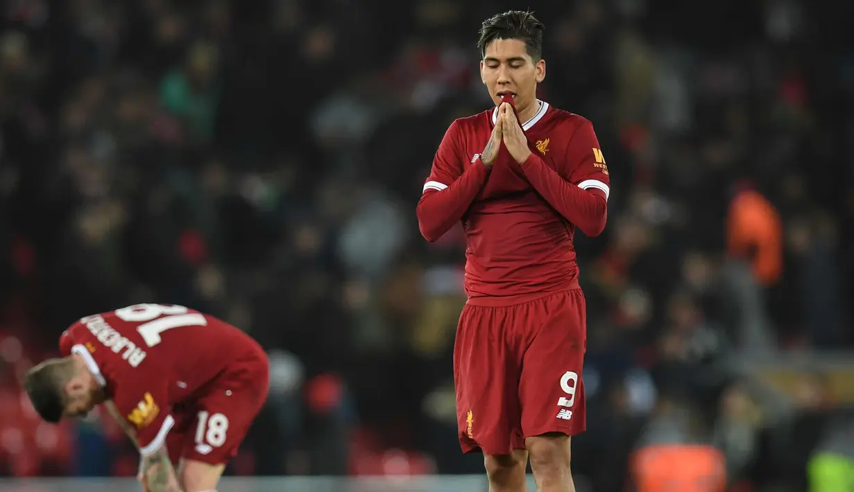 Ekspresi Penyerang Liverpool Roberto Firmino (kanan) usai pertandingan melawan West Bromwich Albion pada putaran keempat Piala FA di stadion Anfield, Inggris (27/1). Liverpool takluk dari West Bromwich Albion 3-2. (AFP Photo/Paul Ellis)