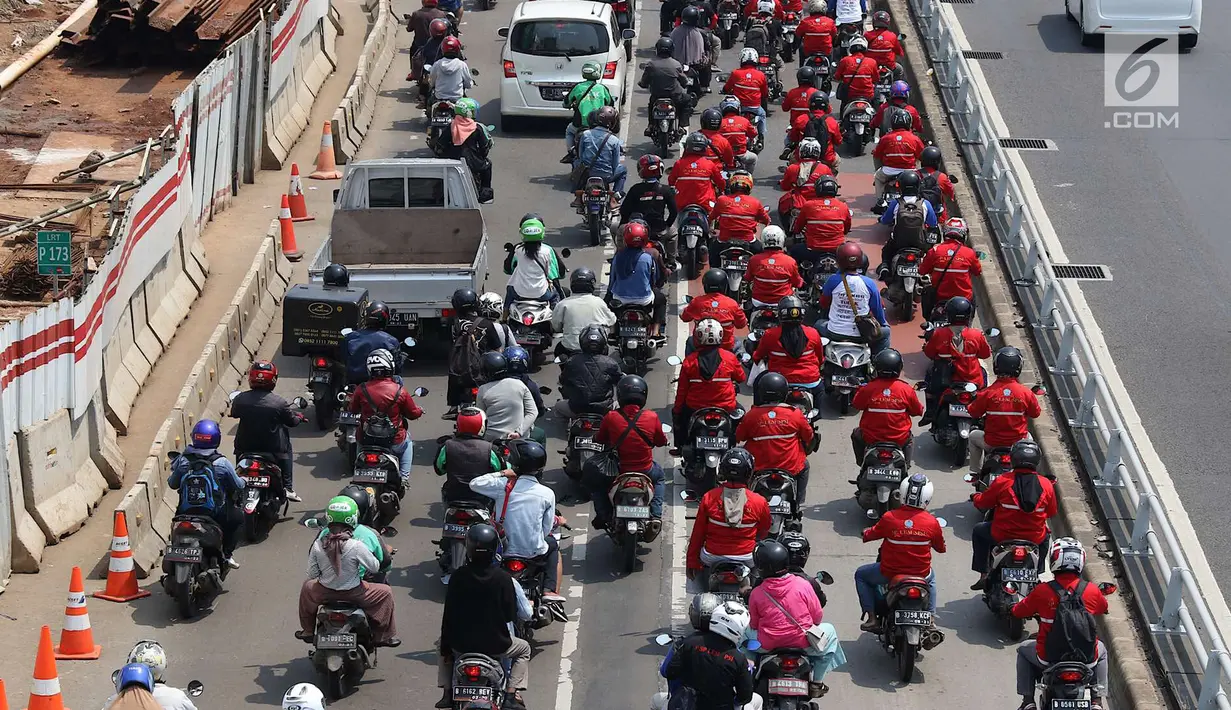 Konvoi buruh menggunakan sepeda motor melintas di Jalan Gatot Soebroto, Jakarta, Selasa (1/5). Ribuan buruh dari berbagai elemen memperingati perayaan Hari Buruh untuk menyampaikan aspirasi di sejumlah titik di Ibukota. (Liputan6.com/Immanuel Antonius)
