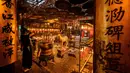 Orang-orang membakar dupa dan berdoa di Kuil Man Mo di Hong Kong pada 19 Mei 2021. Kuil yang didirikan untuk persembahan bagi Dewa Literatur (Man) dan Dewa Perang (Mo) ini tampak selalu ramai dikunjungi oleh wisatawan atau masyarakat lokal yang ingin beribadah. (Anthony WALLACE/AFP)