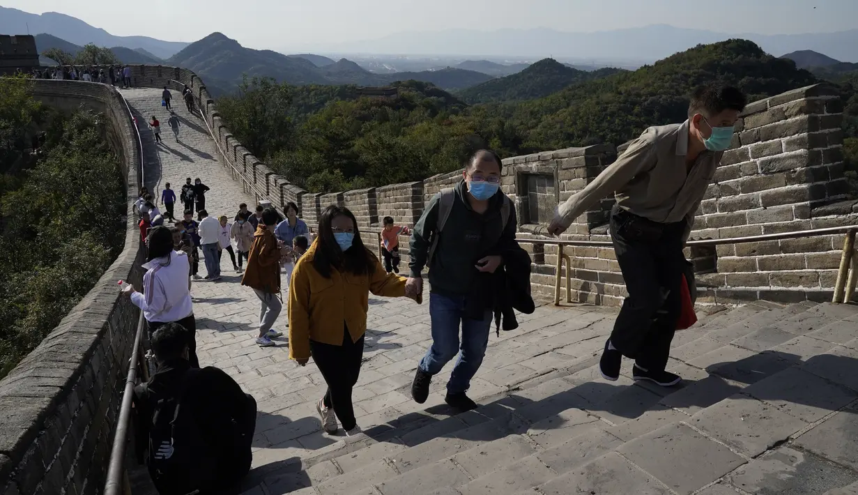 Turis menaiki bentangan Tembok Besar Badaling di pinggiran Beijing, Selasa (6/10/2020). Liburan tahun ini, yang bertepatan dengan Festival Pertengahan Musim Gugur, akan menjadi ujian lakmus apakah industri pariwisata China dapat bangkit kembali setelah digempur oleh COVID-19. (AP Photo/Ng Han Guan)
