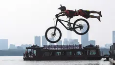 Seorang pesepeda melompat ke Danau Timur menggunakan sepeda BMX dalam ajang tahunan festival lompat air (water jump) BMX di Wuhan, ibu kota Provinsi Hubei, China tengah, pada 22 Agustus 2020. (Xinhua/Xiao Yijiu)
