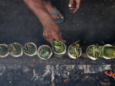 Pak Pian membakar lemang di sebuah tanah kosong di Jakarta, Minggu (27/5). Memasuki bulan Ramadan, produksi makanan tradisional Melayu berbahan dasar ketan tersebut terus meningkat. (Merdeka.com/Iqbal S Nugroho)