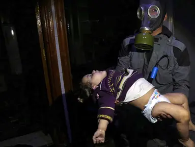 Penyelamat membawa seorang anak menyusul dugaan serangan senjata kimia di Kota Douma, dekat Damaskus, Suriah, Minggu (8/4). Petugas medis mengatakan serangan gas beracun di Douma telah menewaskan 70 orang. (Syrian Civil Defense White Helmets via AP)