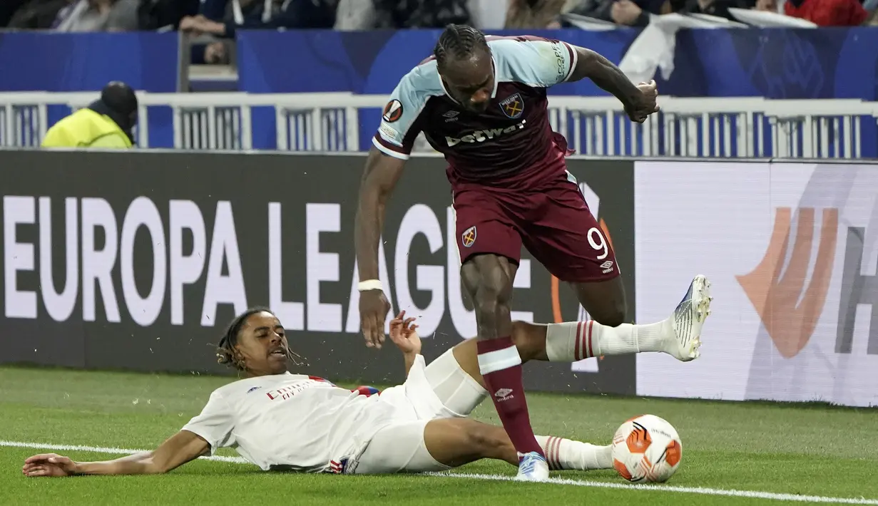 Penyerang Olympique Lyon Bradley Barcola mencoba menjegal penyerang West Ham United Michail Antonio pada leg kedua perempat final Liga Europa melawan Lyon di Parc Olympique Lyonnais, Jumat (15/4/2022). West Ham lolos ke semifinal usai melibas tuan rumah Lyon 0-3. (AP Photo/Laurent Cipriani)