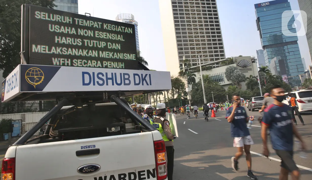 Pejalan kaki melintas saat sosialisasi penerapan protokol kesehatan PSBB di Bundaran HI, Jakarta, Minggu (13/9/2020). Kepastian pemberlakuan kembali PSBB di Jakarta masih dibahas antara Pemprov DKI dan pemerintah pusat dan akan diumumkan nanti sore. (merdeka.com/Arie Basuki)