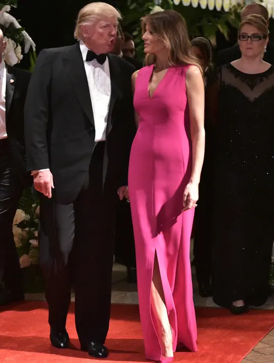 Donald Trump berbincang dengan istrinya, Melania Trump saat menghadiri gala tahunan Palang Merah Amerika ke-60 di Mar-a-Lago, Florida, AS (4/2). (AFP/Mandel Ngan)