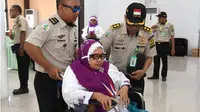 Dua petugas membantu jemaah haji lansia yang menggunakan kursi roda pada pemberangkatan di Asrama Embarkasi Haji Antara Gorontalo (Foto : Haris)