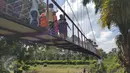 Warga mencoba jembatan baru di Desa Pintas Tuo, Kecamatan Muara Tabir, Jambi, (7/8). Selama ini warga terpaksa memutar sejauh 17 kilometer untuk menuju desa terdekat. Namun, mereka saat ini bisa lebih menghemat waktu. (Liputan6.com/dok SCTV)