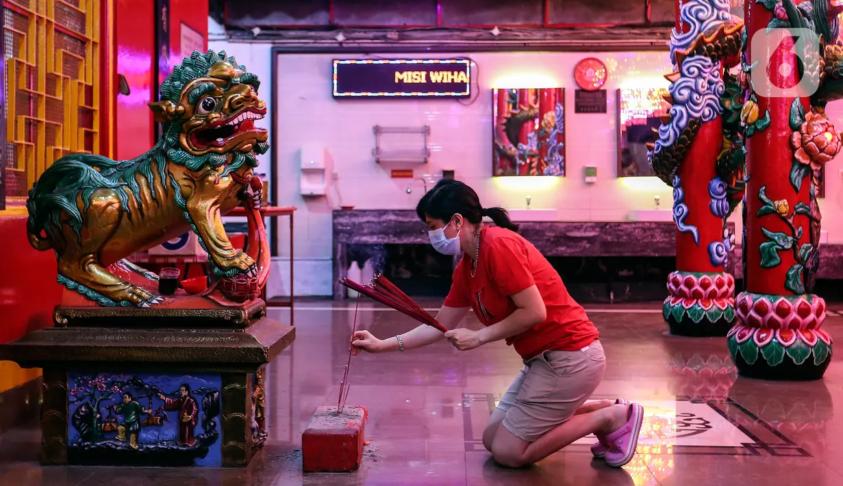 Seorang warga Tionghoa membawa hio (dupa) saat beribadah malam perayaan Tahun Baru Imlek 2573 di Vihara Amurva Bhumi, Jakarta, Senin (31/1/2022). Ibadah Imlek pada tahun ini dilakukan pembatasan sampai pukul 20.00 akibat pemberlakuan PPKM level tiga di Jakarta. (Liputan6.com/Johan Tallo)