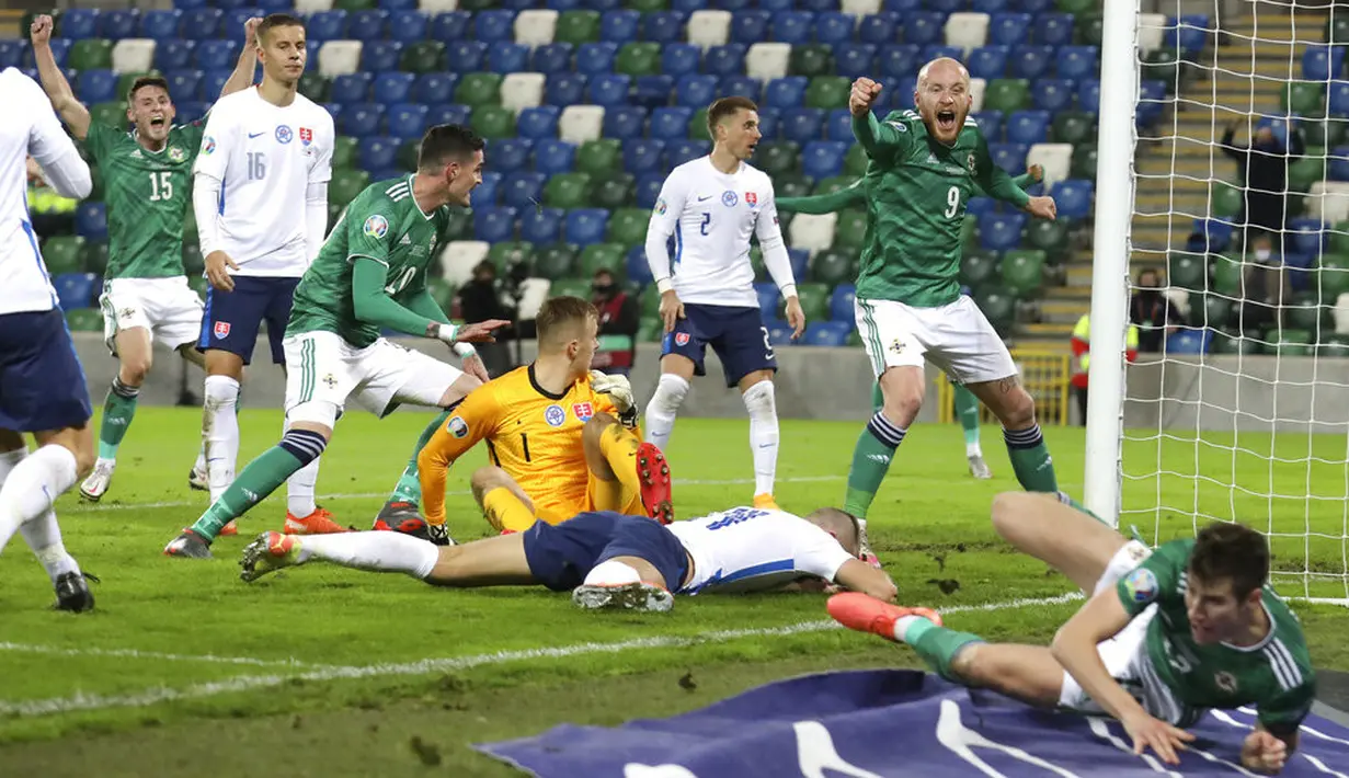 Pemain Irlandia Utara Liam Boyce (kanan atas) merayakan gol pertama timnya saat menghadapi Slovakia pada playoff babak semifinal Euro 2020 di Windsor Park, Belfast, Irlandia Utara, Kamis (12/11/2020). Slovakia merebut tiket Euro 2020 usai mengalahkan Irlandia Utara 2-1. (AP Photo/Peter Morrison)