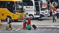 Pemudik membawa barang mereka seusai turun dari bus antarkota antarprovinsi (AKAP) di Terminal Kampung Rambutan, Jakarta, Minggu (23/5/2021). Hingga sore ini pemudik dari kota di Jawa Barat, Tengah, Timur, dan Sumatera terus berdatangan di Terminal Kampung Rambutan. (merdeka.com/Iqbal S Nugroho)