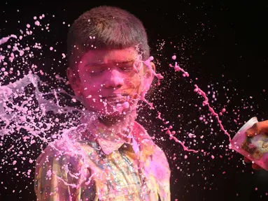 Seorang anak India terkena air berwarna selama perayaan festival Holi di Chennai (2/3). Holi, festival musim semi hindu di India yang diadakan 2 Maret tahun ini pada akhir musim dingin pada bulan purnama pertama kalender lunar. (AFP Photo/Arun Sankar)