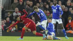 Penyerang Liverpool, Mohamed Salah (kiri) berebut bola dengan pemain Leicester City Youri Tielemans dan James Maddison selama pertandingan lanjutan Liga Inggris di stadion Anfield di Liverpool, Inggris, Jumat (11/2/2022). The Reds kini mengoleksi poin 5. (AP Photo/Jon Super)