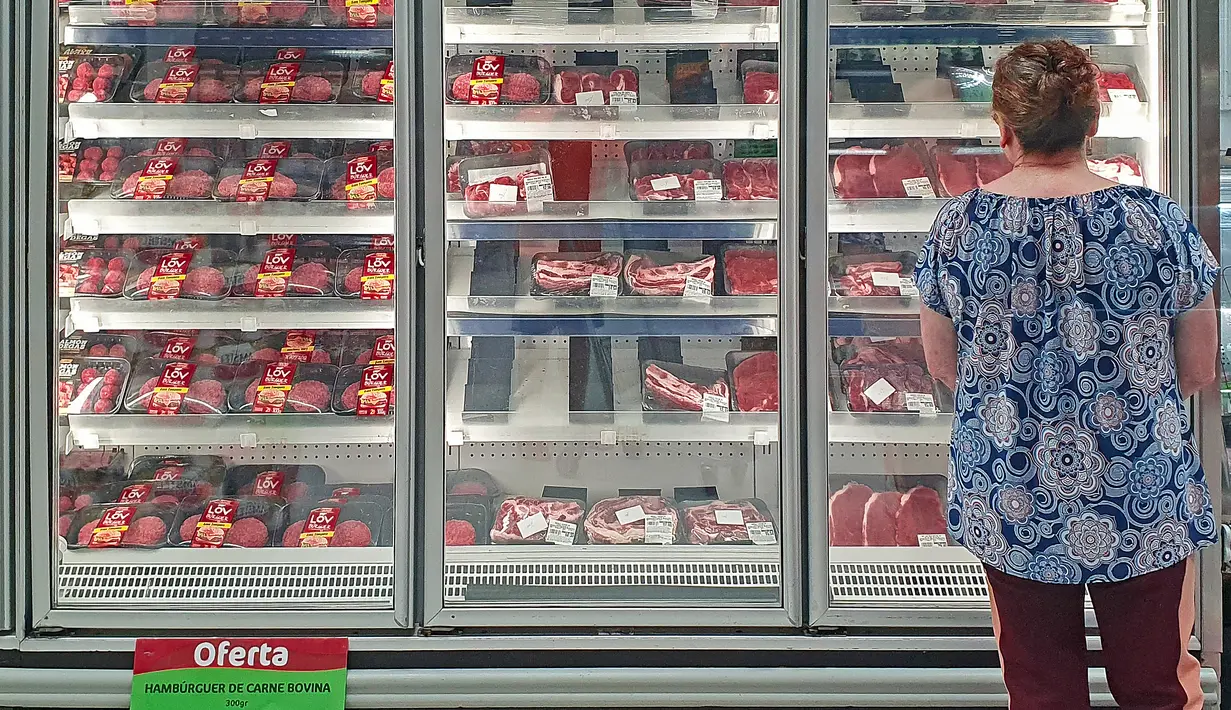 Seorang pelanggan memeriksa bagian daging sapi sebuah supermarket di Curitiba, Brasil, Kamis (23/2/2023). Mulai 23 Februari, Brasil menangguhkan sementara ekspor daging sapinya ke China, pembeli utama mereka, mengikuti protokol kesehatan resmi setelah kasus bovine spongiform encephalopathy atau disebut juga Penyakit Sapi Gila, dikonfirmasi oleh Kementerian Pertanian. (Photo by Eduardo Matysiak / AFP)