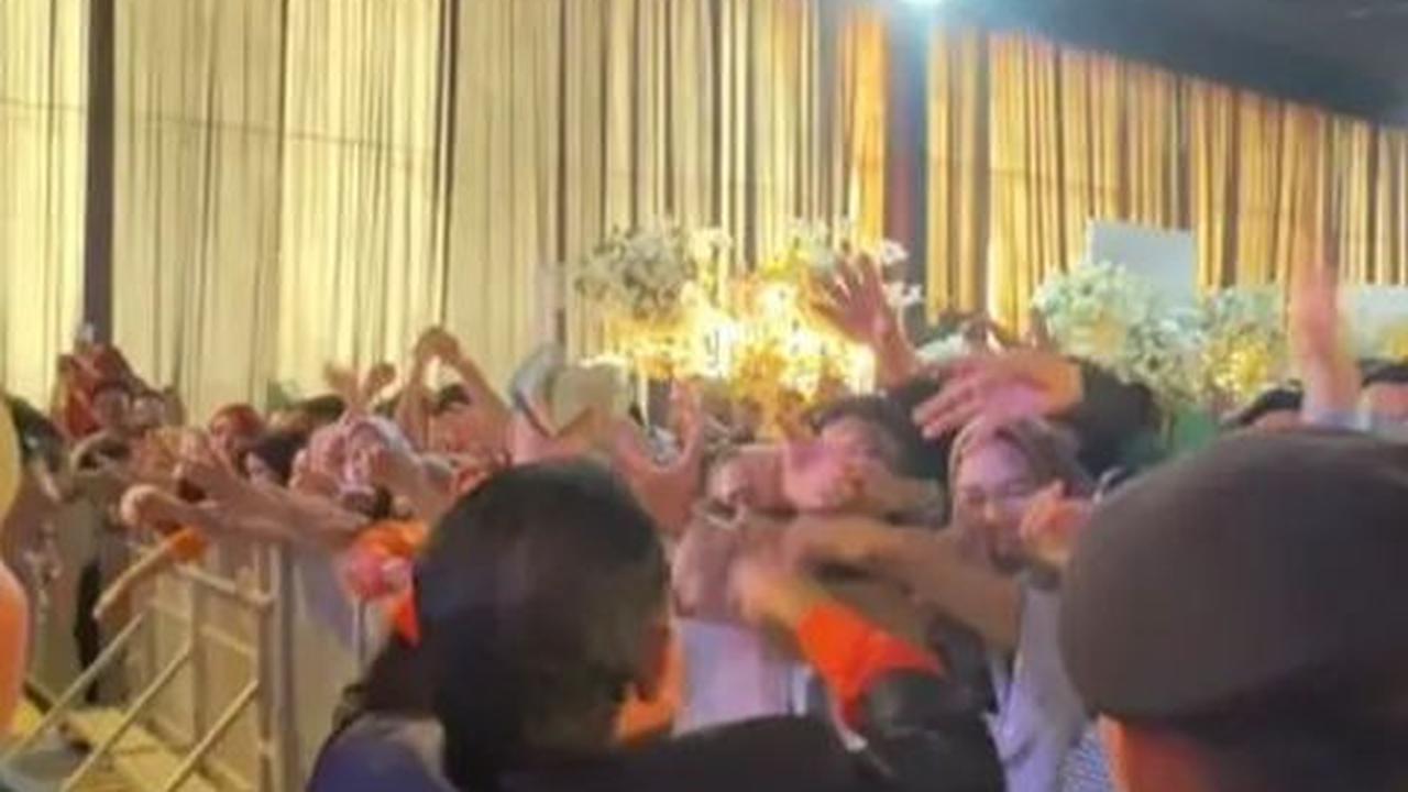Mereka menyodorkan tangan dan berharap bisa beruntung mendapatkan selembar uang sebagai kenang-kenangan dari acara yang meriah ini.<br>