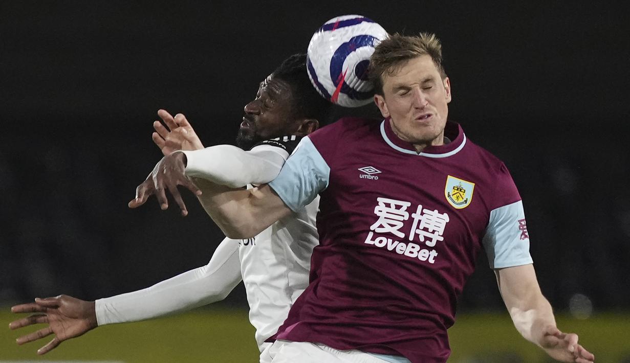 Striker Burnley, Chris Wood (kanan) berduel udara dengan gelandang Fulham, Andre-Frank Zambo Anguissa dalam laga lanjutan Liga Inggris 2020/2021 pekan ke-35 di Craven Cottage Stadium, London, Senin (10/5/2021). Burnley menang 2-0 atas Fulham. (AP/John Walton/Pool)