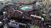 Ribuan orang memadati Lapangan Enqelab saat truk-truk yang membawa peti jenazah komandan militer dan ilmuwan Iran yang tewas selama serangan Israel melintas selama prosesi pemakaman di ibu kota Teheran pada 28 Juni 2025. (ATTA KENARE/AFP)