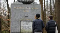 Pengunjung melihat makam filsuf ternama Jerman dan tokoh sosialisme, Karl Marx, di Pemakaman Highgate, London, Selasa (5/2). Tindakan vandalisme dengan menggunakan palu sudah dilaporkan ke kepolisian Scotland Yard. (Tolga AKMEN/AFP)