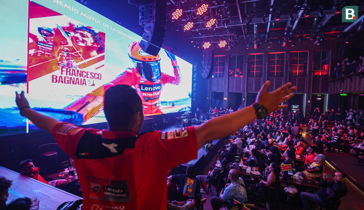 Seorang penonton melakukan selebarasi saat pembalap Ducati Lenovo, Francesco Bagnaia menjadi Juara Dunia MotoGP 2023 ketika acara nonton bareng MotoGP Valencia 2023 bersama Pertamina Enduro di HW Live House, Kemang, Jakarta, Minggu (26/11/2023). (Bola.com/Bagaskara Lazuardi)