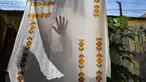 Seorang pekerja mengeringkan kain yang dihias dengan corak batik yang menggunakan teknik pewarnaan dengan menggunakan lilin di sebuah lokakarya di Banda Aceh pada 2 Oktober 2024. (CHAIDEER MAHYUDDIN/AFP)