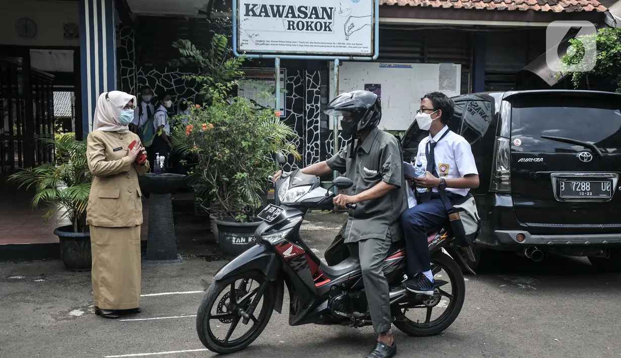 Murid saat dijemput oleh orang tua usai kegiatan Pembelajaran Tatap Muka (PTM) 100 Persen di SMP Negeri 9 Depok, Cipayung, Jawa Barat, Senin (24/1/2022). Pemerintah Kota Depok hari ini mulai menggelar PTM 100 persen secara serentak untuk tingkat TK, SD, dan SMP. (merdeka.com/Iqbal S Nugroho)