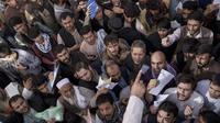 Warga berkerumun di depan kantor keimigrasian yang baru-baru ini dibuka kembali di Kabul, Afghanistan, Rabu (6/10/2021). Mereka mengantre setelah Taliban mengumumkan akan mengeluarkan paspor yang disetujui oleh pemerintahan sebelumnya. (AP Photo/Felipe Dana)