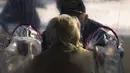 Stan Van Putten meletakkan tangan di bahu istrinya melalui tenda pelukan di komunitas Crossroads Senior Living di Lakewood, Colorado, Jumat (26/2/2021). Tenda itu memungkinkan anggota keluarga terhubung secara fisik satu sama lain untuk pertama kalinya sejak corona (Michael Ciaglo/Getty Images/AFP)