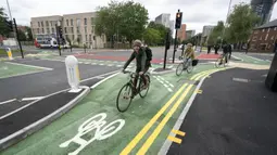 Orang-orang bersepada di jalur sepeda persimpangan CYCLOPS (Cycle Optimized Protected Signals) di wilayah selatan Manchester, Inggris (9/10/2020). Persimpangan CYCLOPS diluncurkan dengan desain unik yang memisahkan pejalan kaki dan pesepeda dari lalu lintas. (Xinhua/Jon Super)
