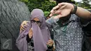Istri Hakim MK Patrialis Akbar, Sufriyeni (kiri) menutup wajah saat menuju ruang tahanan KPK, Jakarta, Senin (30/1). Patrialis Akbar menjadi tersangka dugaan penerima suap uji materi UU peternakan dan Kesehatan Hewan. (Liputan6.com/Helmi Fithriansyah)