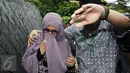 Istri Hakim MK Patrialis Akbar, Sufriyeni (kiri) menutup wajah saat menuju ruang tahanan KPK, Jakarta, Senin (30/1). Patrialis Akbar menjadi tersangka dugaan penerima suap uji materi UU peternakan dan Kesehatan Hewan. (Liputan6.com/Helmi Fithriansyah)