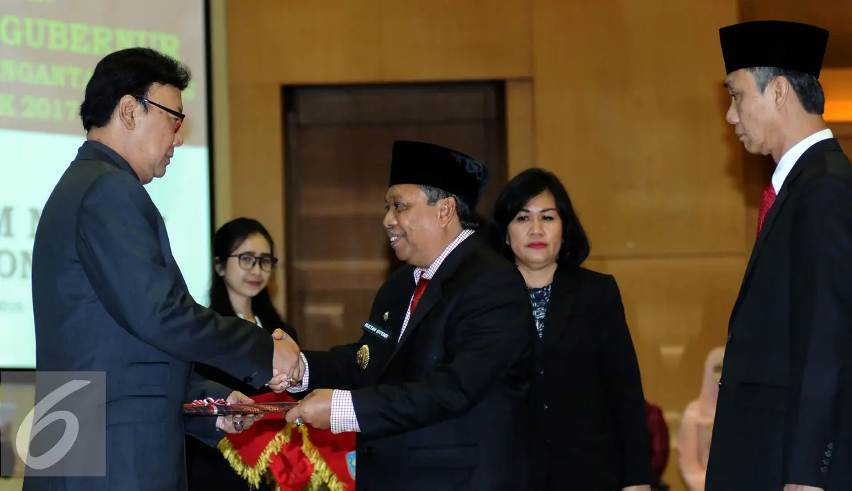 Mendagri Tjahjo Kumolo (kiri) menerima nota pengantar tugas dari Gubernur Bangka Belitung Rustam Effendi di Kemendagri, Jakarta, Kamis (27/10). Selanjutnya, jabatan Gubernur Bangka Belitung dipegang Yuswandi A Tumenggung. (Liputan6.com/Helmi Fithriansyah)
