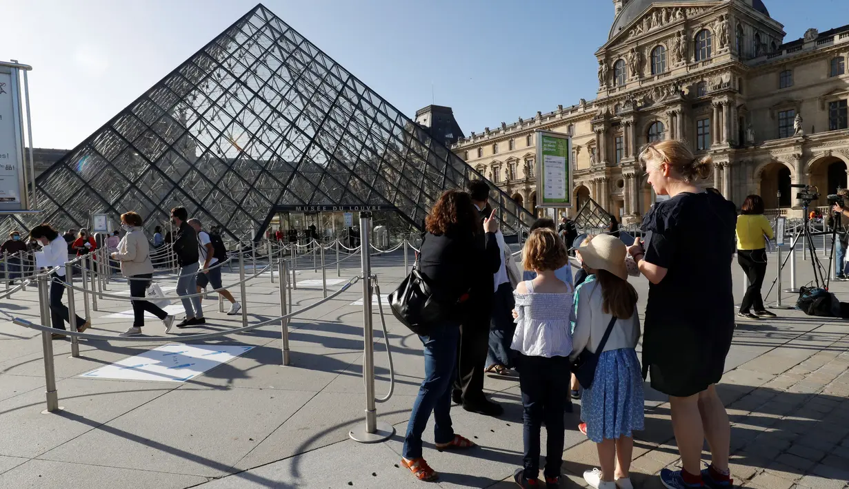 Pengunjung tiba di piramida Louvre yang dirancang arsitek China Ieoh Ming Pei, pintu masuk ke Museum Louvre di Paris (6/7/2020). Presiden dan direktur Louvre Jean-Luc Martinez mengatakan, krisis coronavirus telah menyebabkan "lebih dari 40 juta euro dalam kerugian di Louvre. (AFP/Francois Guillot)