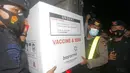 Petugas keamanan membawa kotak berisi vaksin virus corona COVID-19 setibanya di Bali, Selasa (5/1/2021). Kementerian Kesehatan mulai mendistribusikan vaksin virus corona COVID-19 Biotek Sinovac ke seluruh negeri. (AP Photo/Firdia Lisnawati)