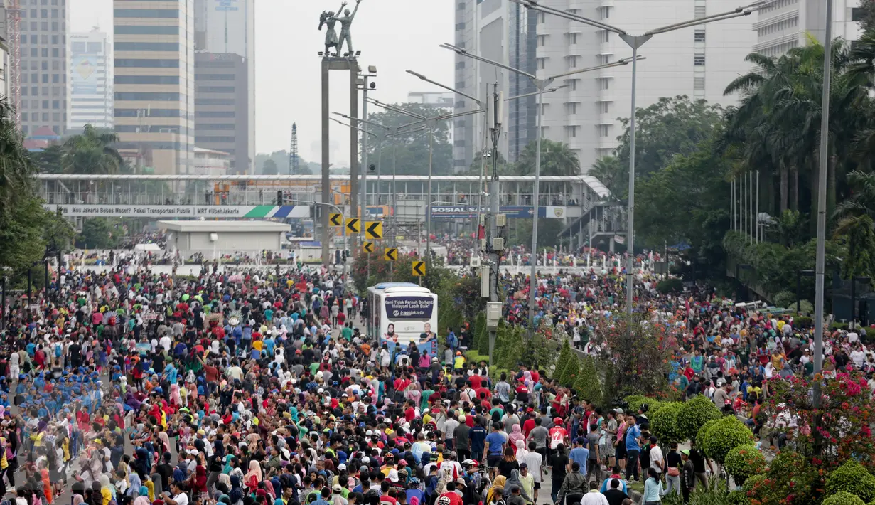 Sejumlah orang memadati Jalan Sudirman-Thamrin, Jakarta saat menikmati Car Free Day (CFD), Minggu (26/3). Libur panjang menjelang Nyepi (28/3), sebagian warga Jakarta memilih menghabiskan waktu dengan berolahraga di area CFD. (Liputan6.com/Faizal Fanani)