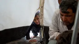 Seorang bocah mengintip di sebuah kamp di Hammam al-Alil, Irak, Rabu (3/5). Pengungsi di kamp ini adalah warga Irak yang menyelamatkan diri dari ISIS di Mosul Barat. (AFP PHOTO / FADEL SENNA)