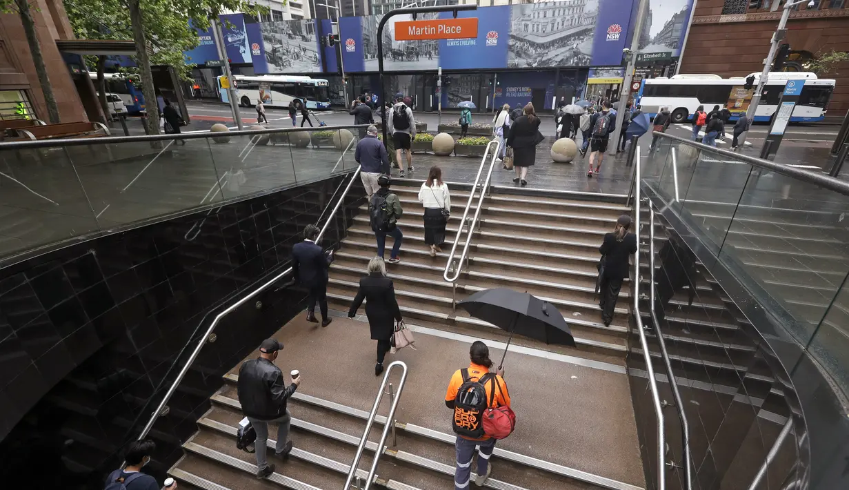 Komuter berjalan keluar dari stasiun kereta bawah tanah ketika orang-orang masuki pusat kota setelah lebih dari 100 hari lockdown di Sydney, Senin (11/10/2021). Lockdown Sydney akhirnya berakhir setelah hampir empat bulan lamanya kota terbesar di Australia itu ditutup. (AP Photo/Rick Rycroft)