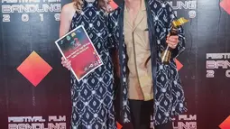 Kali ini Randy Pangalila tampil serasi dengan istri bulenya, Chelsey Franky. Keduanya tampil kompak mengenakan busana batik berwarna biru. Randy mengenakan outer batik, sementara sang istri memakai gaun batik dengan motif senada. (Liputan6.com/IG/@randpunk)