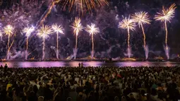 Orang-orang berkumpul untuk menonton kembang api pada Hari Bastille di sebuah pantai di Cannes, Prancis, Rabu (14/7/2021). Prancis merayakan Hari Bastille dengan ribuan tentara berbaris dalam parade Paris, setelah acara tahun lalu dikurangi karena ketakutan akan COVID-19. (AP Photo/Vadim Ghirda)