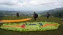 Paraglider bersiap untuk lepas landas dari lereng bukit di Puncak, Bogor, Jawa Barat, Kamis (2/12/2021). Destinasi wisata alam Bukit Paralayang Puncak Bogor sangat cocok untuk dikunjungi pada liburan akhir pekan bersama keluarga, sahabat maupun pasangan tercinta. (Goh Chai Hin/AFP)
