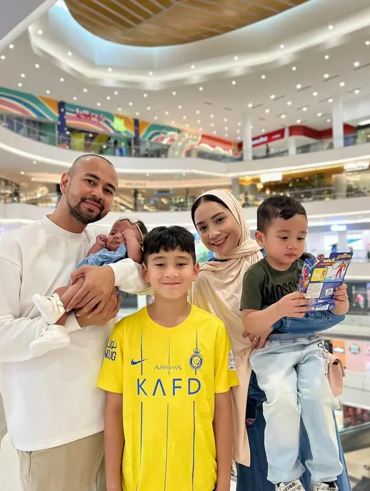 Ini adalah potret pertama Nagita Slavina kenakan kerudung usai ibadah haji. Nagita Slavina mengenakan set denim kemeja lengan panjang dan rok dipadukan dengan kerudung krem dan tas pink. [@raffinagita1717]