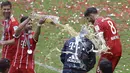 Pelatih Bayern, Carlo Ancelotti menerima seiraman bir oleh Juan Bernat saat perayaan gelar juara Bundesliga 2016-2017 di  Allianz Arena stadium, Munich, (20/5/2017).  (AP/Matthias Schrader)