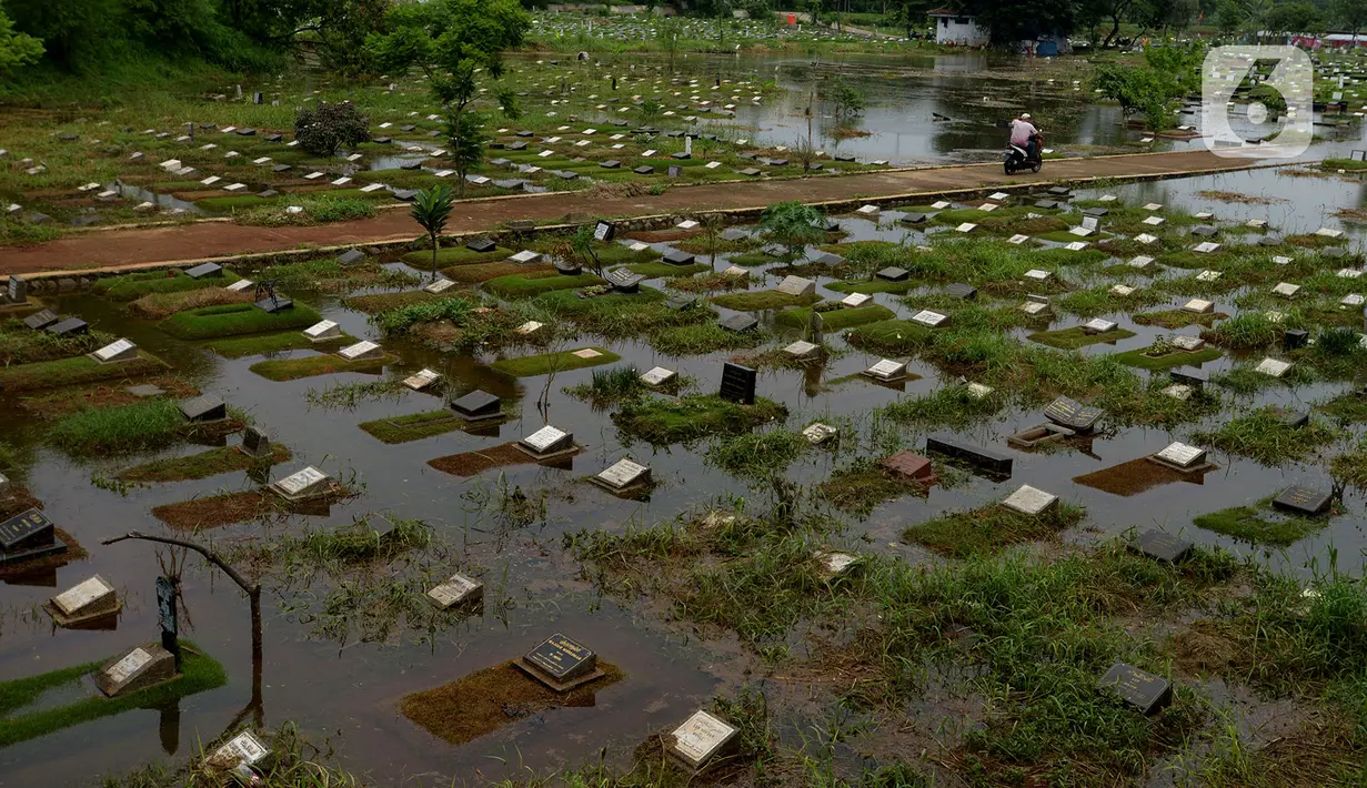 Banjir merendam sejumlah makam di Tempat Pemakaman Umum (TPU) Tanah Kusir, Jakarta, Jumat (3/1/2020). TPU Tanah Kusir terendam banjir setelah Kali Pesanggrahan meluap akibat intensitas hujan  yang tinggi pada Rabu lalu. (merdeka.com/Imam Buhori)