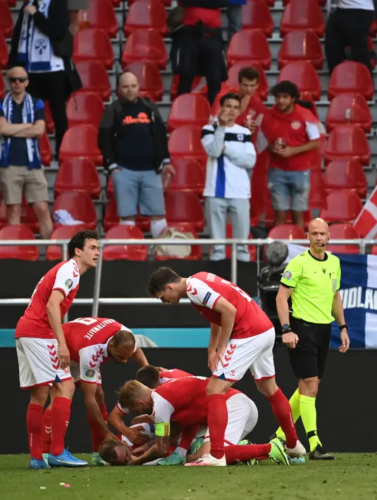 Para pemain Denmark memeriksa rekan setimnya Christian Eriksen setelah pingsan pada laga Denmark vs Finlandia di Grup B Euro 2020 di Parken Stadium, Copenhagen, Sabtu (12/6/2021). Laga dihentikan jelang berakhirnya babak pertama setelah Christian Eriksen pingsan. (Jonathan NACKSTRAND/POOL/AFP)